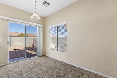 Carpeted empty room featuring visible vents and ba