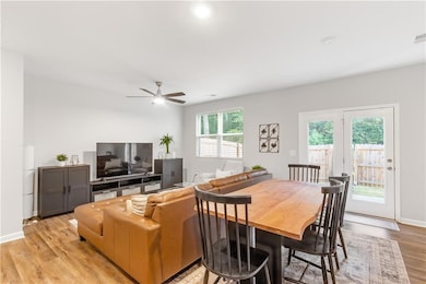 Dining space featuring light wood-style floors, ceiling fan, and baseboards