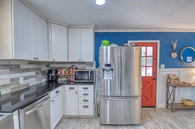 Kitchen with stainless steel appliances, white cab