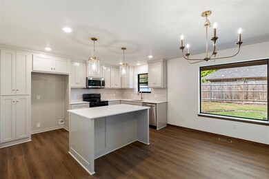 Kitchen featuring appliances with stainless steel finishes, a chandelier, tasteful backsplash, light countertops, and dark wood-style floors