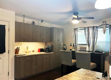 Kitchen with dark wood-style flooring, a ceiling fan, cooling unit, and dark brown cabinets