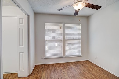 Unfurnished room with ceiling fan, a textured ceil