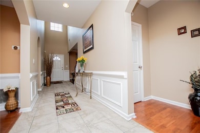 Entryway featuring arched walkways, recessed lighting, a towering ceiling, and a decorative wall