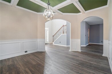 Dining room featuring dark wood-style floors, stai