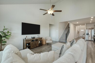 Living area with stairway, high vaulted ceiling, 