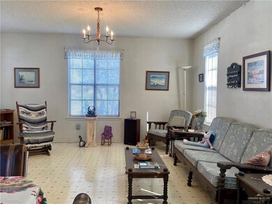 Living room with a chandelier, a textured ceiling, and a healthy amount of sunlight