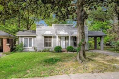 View of front of property featuring a front yard, a chimney, and roof with shingles
