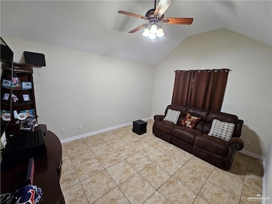 Living area with ceiling fan, lofted ceiling, and light tile patterned flooring