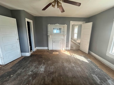 Unfurnished living room featuring dark wood-style floors and ceiling fan