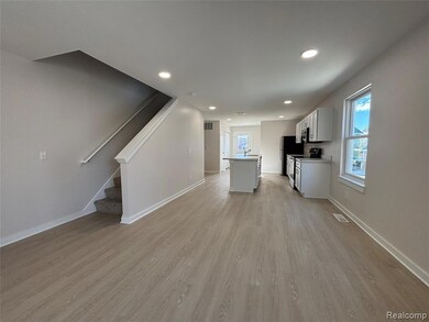 Kitchen featuring a center island, light countertops, white cabinetry, recessed lighting, and light wood-type flooring