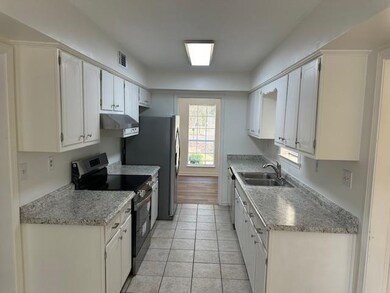 Kitchen with light tile patterned floors, stainles