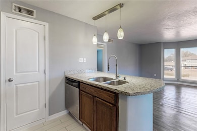 Kitchen featuring kitchen peninsula, light stone c