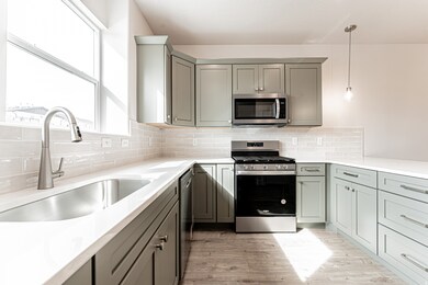 Kitchen with decorative light fixtures, appliances with stainless steel finishes, and tasteful backsplash