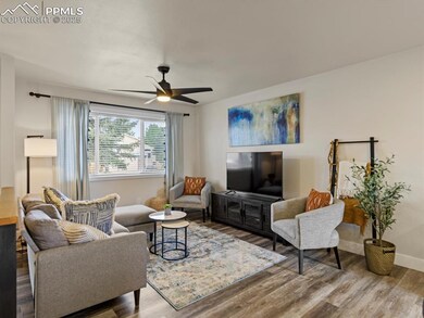 Living area with wood finished floors and ceiling fan