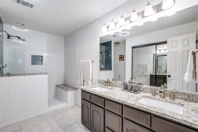 Grand primary bathroom with dual vanities, granite