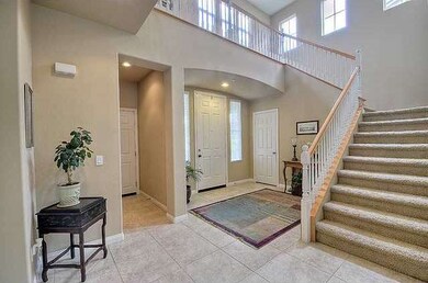 The majestic 2 story entry foyer is bathed in natu