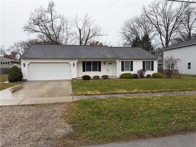 Ranch-style house featuring driveway, a front lawn, an attached garage, and a porch