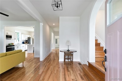 Entrance foyer with light wood-style flooring, arc