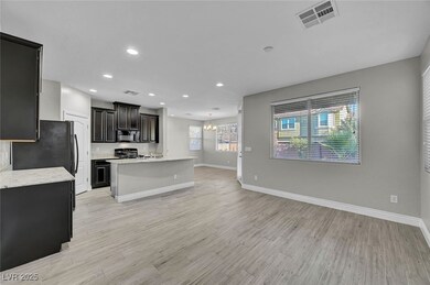 Kitchen with black microwave, a chandelier, stove,