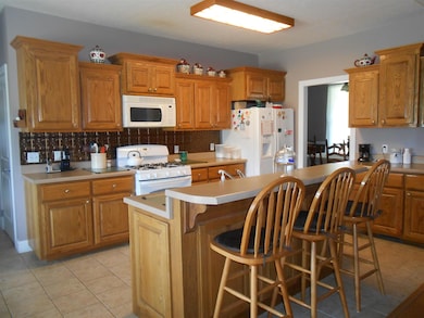 This custom Kitchen features Oak Cabinets with a built in Island and a sit down dinner bar.  You won't run out of storage space here!