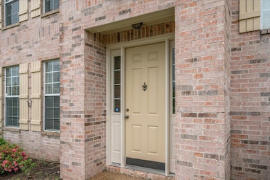 Entrance to property featuring brick siding