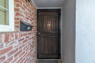 Welcoming Front  entry with charming brick detail and a solid wood door for added character.