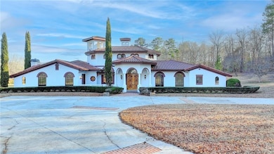 Mediterranean / spanish house with stucco siding, curved driveway, a tiled roof, and a chimney