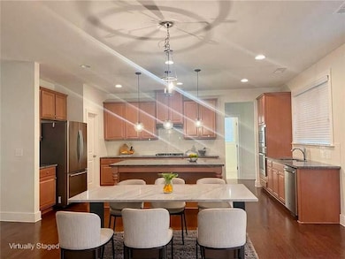 Kitchen featuring stainless steel appliances, a kitchen island, a sink, a breakfast bar, and decorative backsplash