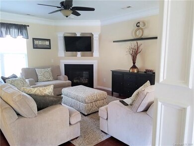 Living room has crown moulding, gas log fireplace,