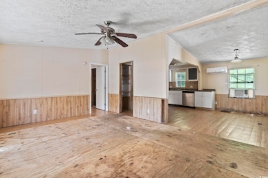 Unfurnished living room featuring wooden walls, ha
