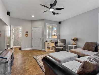 Living room with tile floors, shutters, ceiling fa