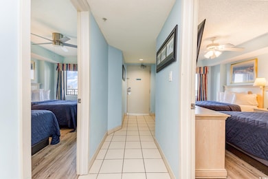 Hall with a textured ceiling and light tile patter