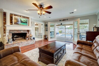 This grand family room is the heart of the home, where timeless charm meets modern comfort. Cozy family gatherings await around the stately brick fireplace, or open the French doors to let the outdoors in.