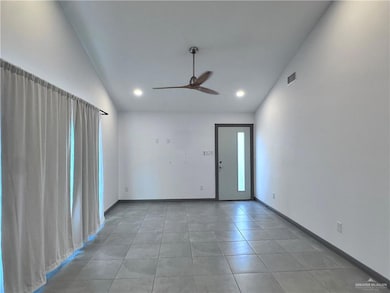 Spare room with a ceiling fan, visible vents, vaulted ceiling, light tile patterned floors, and recessed lighting