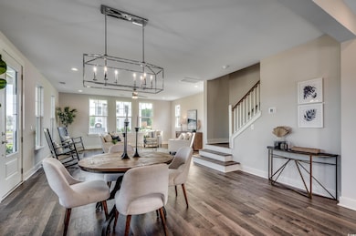Dining room with dark wood-style flooring, stairway, a chandelier, and recessed lighting
