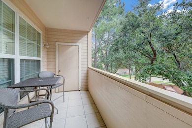 Balcony with treetop views and storage closet.