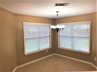 Empty room featuring a chandelier and tile patterned flooring