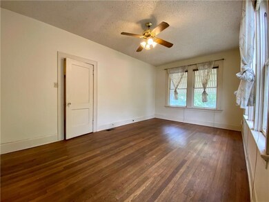 Spare room featuring a textured ceiling, dark woo