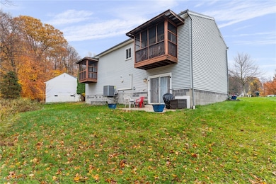 Back of house featuring a patio, a sunroom, and a yard