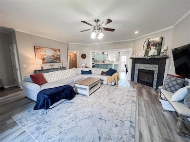 Living room featuring a fireplace, crown molding, 
