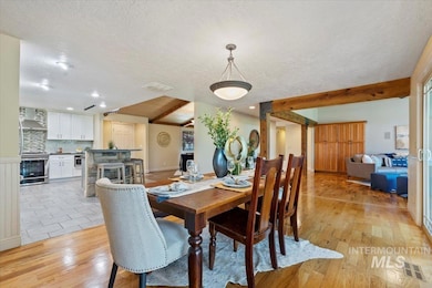 Dining room with a textured ceiling, light wood-type flooring, and recessed lighting