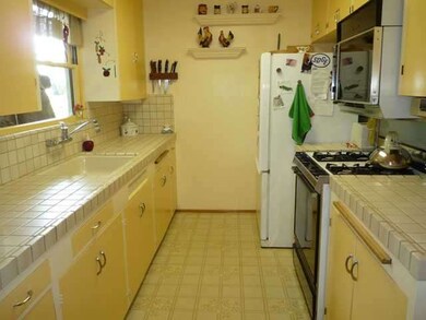 Sunny kitchen with tile countertops.