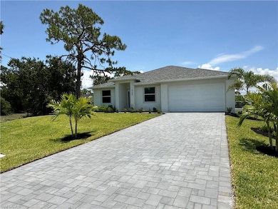 View of front of property with a front lawn, decorative driveway, an attached garage, and stucco siding