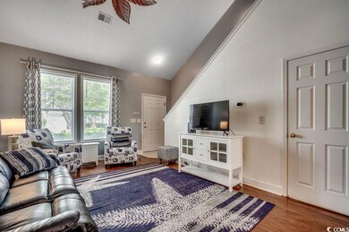 Living room with vaulted ceiling and wood finished floors