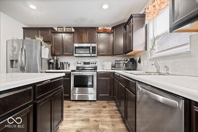 Open kitchen with large center island, and stainless steel appliances