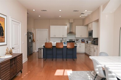 Kitchen with white cabinets, wall chimney exhaust