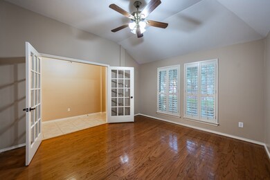 Plantation shutters, ceiling fan and gleaming wood floors add to the beauty of the study.