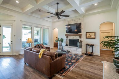 Living room featuring ceiling fan, dark hardwood / wood-style floors, coffered ceiling, beamed ceiling, and a fireplace