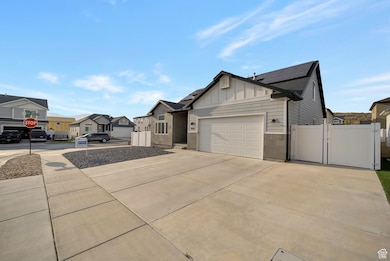 View of front facade with board and batten siding, solar panels, a gate, concrete driveway, and a garage