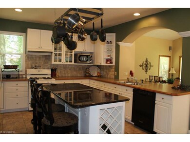 The kitchen has an island with a granite counter t